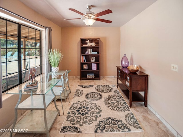 home office featuring baseboards and a ceiling fan