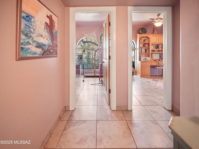 hall with baseboards and light tile patterned floors