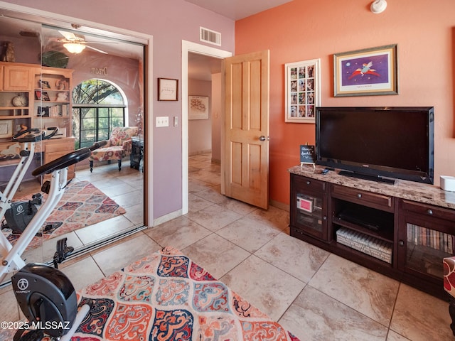 living room with light tile patterned floors, visible vents, and baseboards