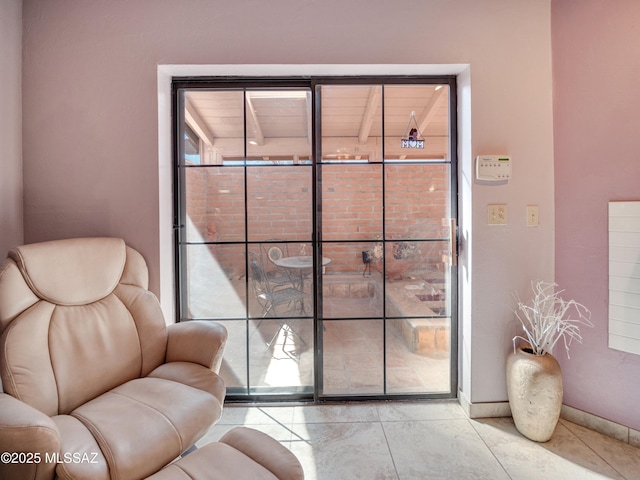 sitting room featuring a healthy amount of sunlight and baseboards