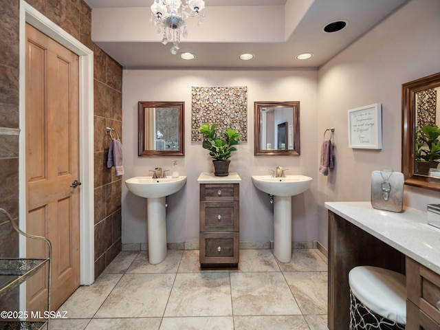 bathroom featuring two sinks, tile patterned flooring, and recessed lighting