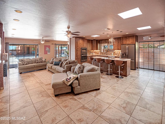 living room with visible vents, a textured ceiling, and light tile patterned floors