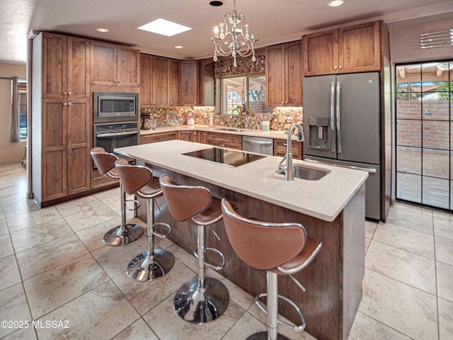 kitchen featuring light countertops, a sink, a kitchen island with sink, and stainless steel appliances