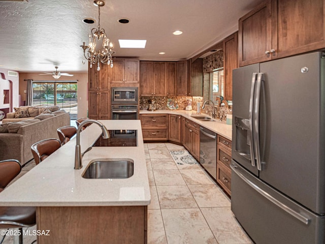 kitchen featuring a breakfast bar area, stainless steel appliances, open floor plan, a sink, and a kitchen island