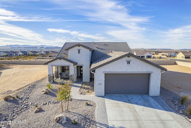 single story home featuring a garage, a mountain view, and covered porch