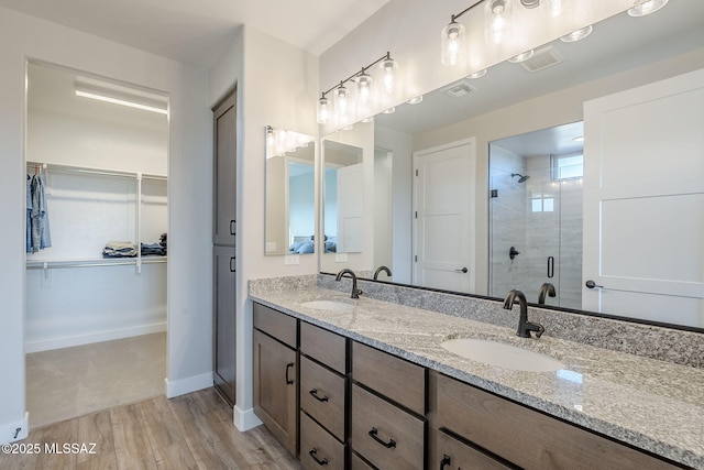 bathroom featuring a shower with door, vanity, and hardwood / wood-style flooring