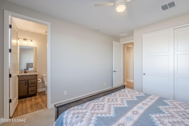 bedroom with sink, a closet, ceiling fan, and ensuite bathroom