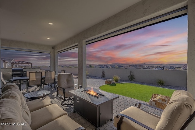 interior space with a lawn and an outdoor living space with a fire pit