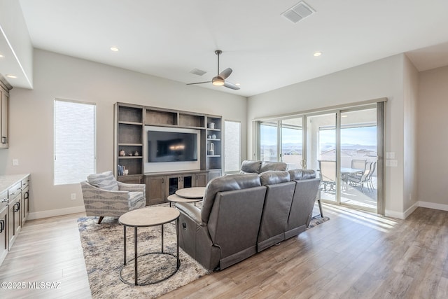 living room featuring light hardwood / wood-style flooring and ceiling fan