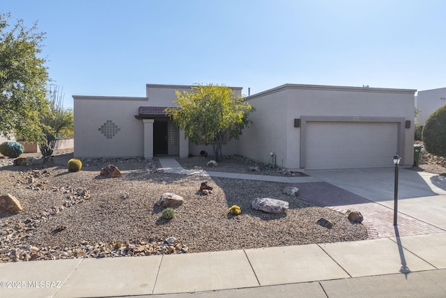 pueblo revival-style home featuring a garage