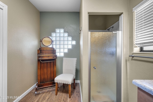 bathroom with hardwood / wood-style flooring and a shower with door