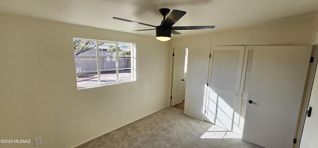 unfurnished bedroom with light colored carpet, a closet, and ceiling fan