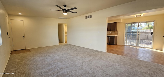 unfurnished living room with light colored carpet and ceiling fan