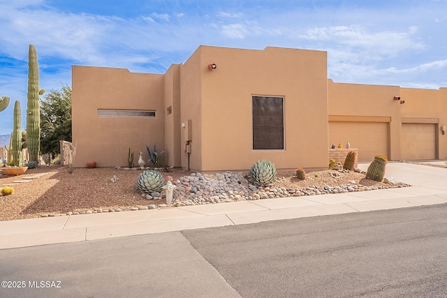 pueblo revival-style home featuring a garage