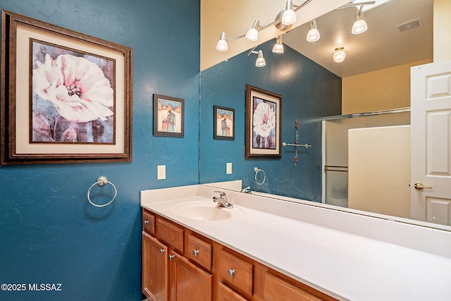 bathroom with walk in shower and vanity