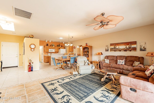 tiled living room with ceiling fan with notable chandelier