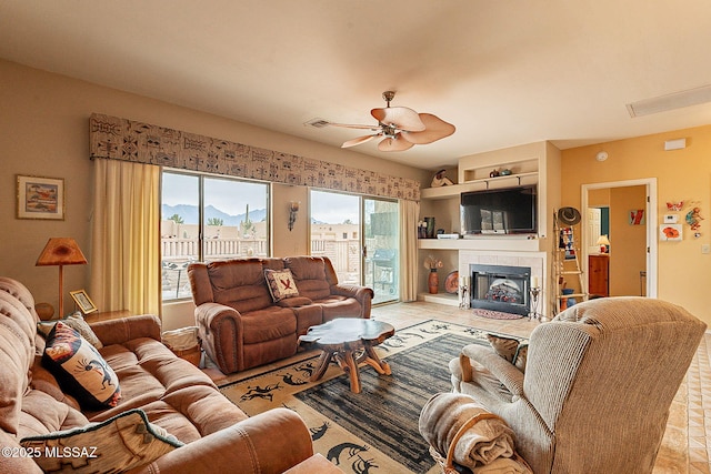 living room featuring a fireplace and ceiling fan