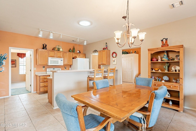 dining room featuring light tile patterned floors and a notable chandelier