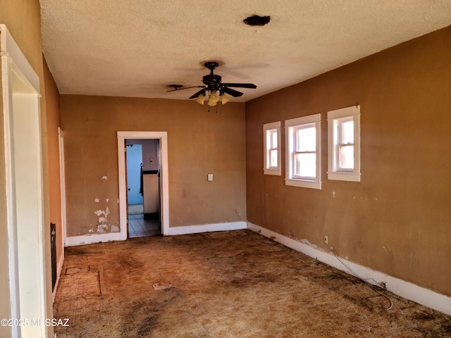 unfurnished room with carpet floors, ceiling fan, a textured ceiling, and baseboards