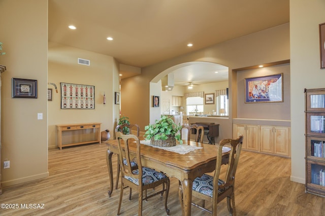 dining space with recessed lighting, arched walkways, visible vents, and light wood-type flooring