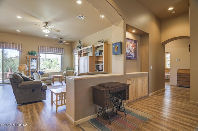 living area featuring wood finished floors, a ceiling fan, visible vents, recessed lighting, and arched walkways
