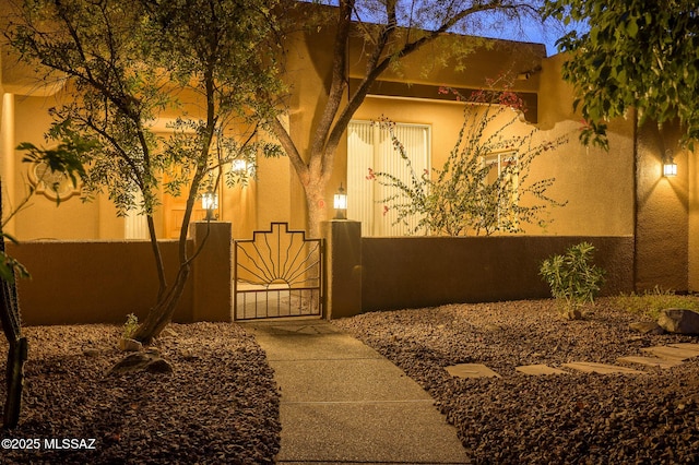 view of home's exterior with a gate and stucco siding