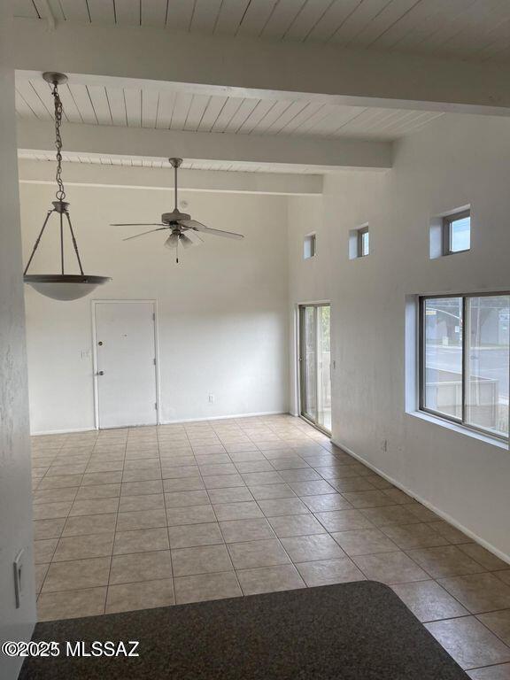 tiled spare room with wood ceiling, beam ceiling, and ceiling fan