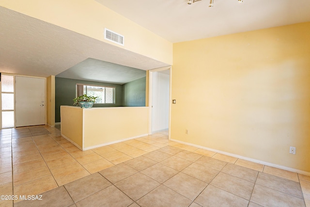 spare room featuring light tile patterned floors, baseboards, and visible vents