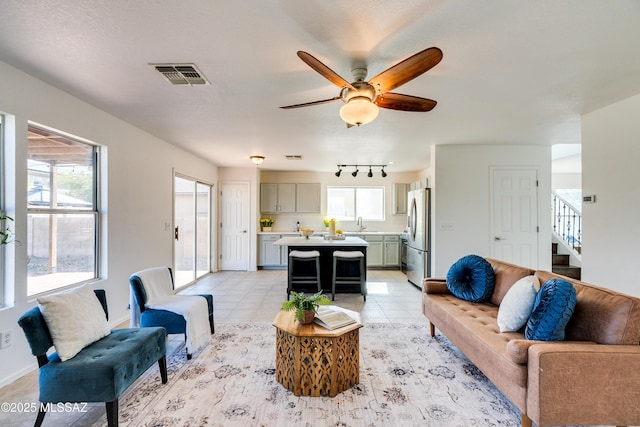 living room with light tile patterned floors, sink, and ceiling fan