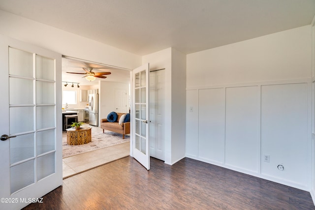 interior space with dark wood-type flooring, sink, ceiling fan, and french doors