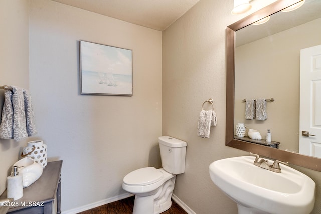 bathroom with wood-type flooring, sink, and toilet