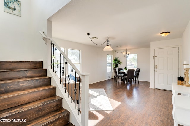 staircase featuring a notable chandelier and wood-type flooring