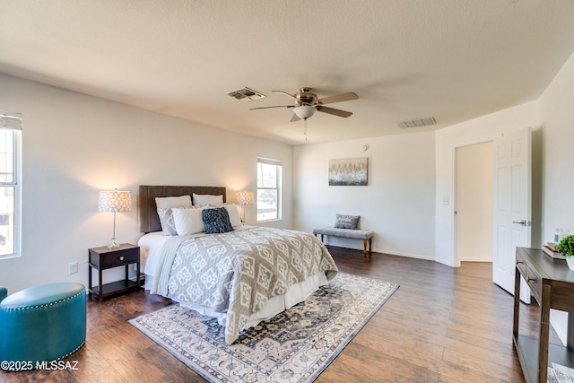 bedroom featuring dark hardwood / wood-style flooring, a textured ceiling, and ceiling fan