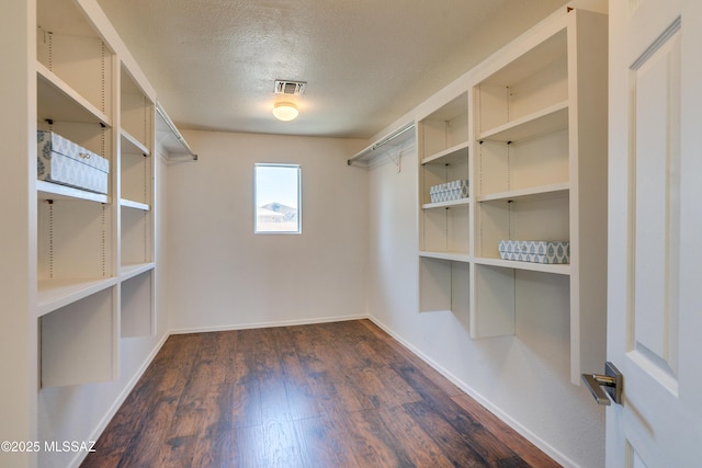 walk in closet with dark wood-type flooring