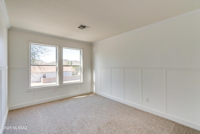 empty room featuring light colored carpet and ornamental molding