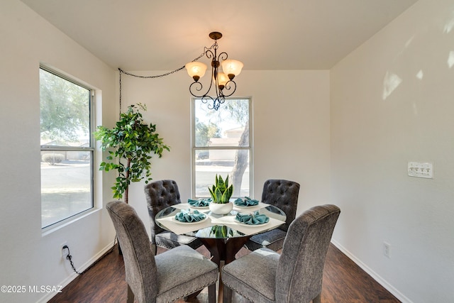 dining space featuring dark hardwood / wood-style flooring and an inviting chandelier