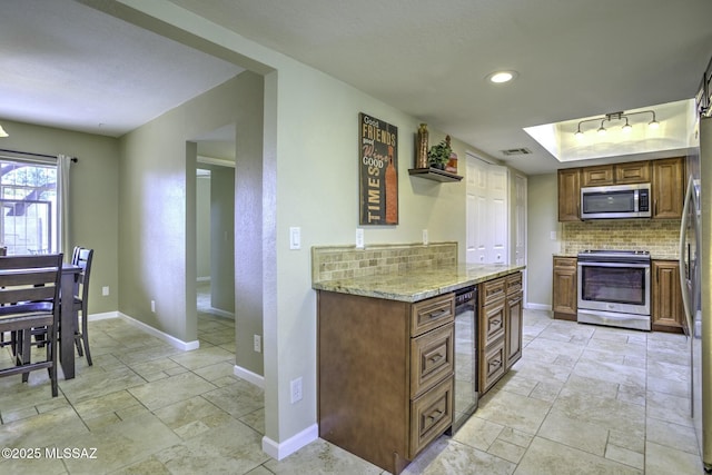 kitchen with light stone counters, decorative backsplash, stainless steel appliances, and wine cooler