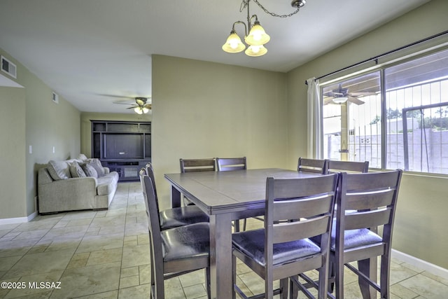 dining space with ceiling fan with notable chandelier