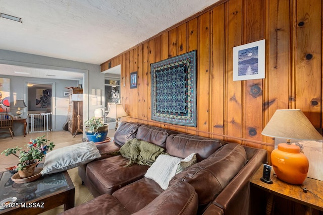 living room featuring a textured ceiling and wood walls