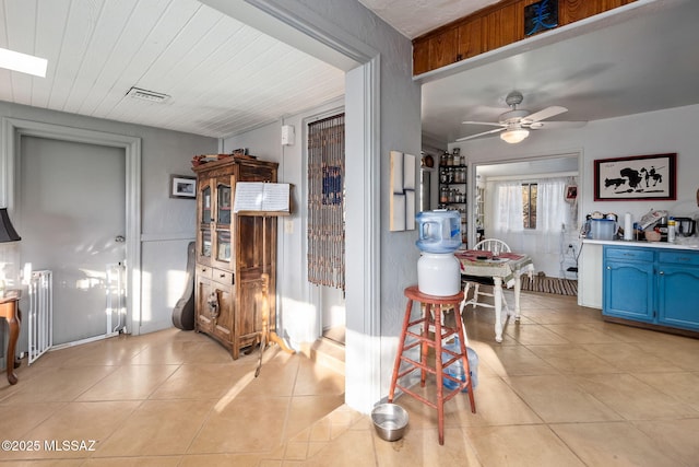 interior space featuring light tile patterned floors and ceiling fan