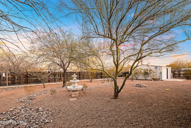 yard at dusk featuring an outdoor structure