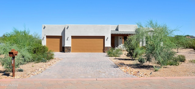 pueblo revival-style home with a garage