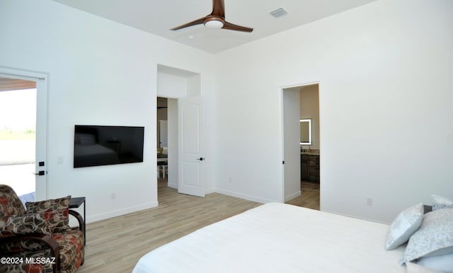 bedroom featuring ensuite bathroom, ceiling fan, and light wood-type flooring