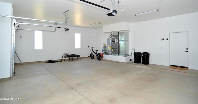 garage featuring heating unit, a garage door opener, and gas water heater