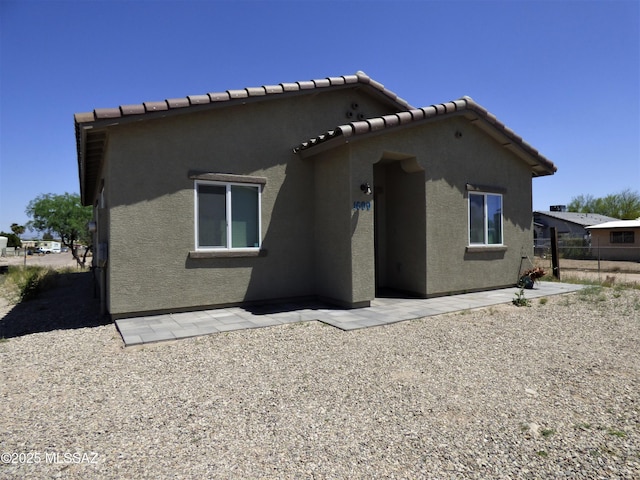 view of side of property featuring a patio and stucco siding