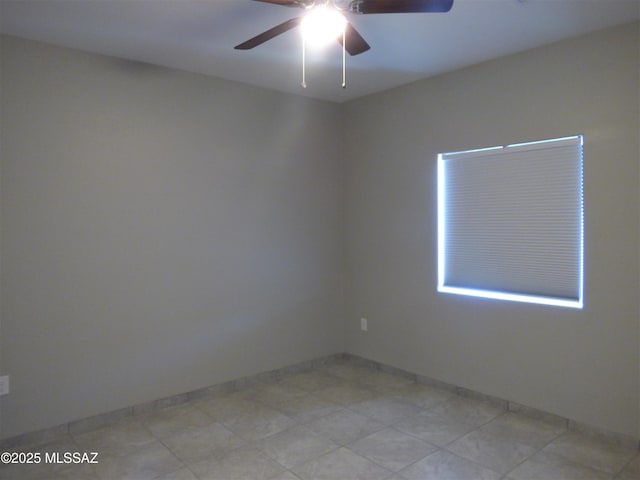 empty room featuring a ceiling fan and baseboards