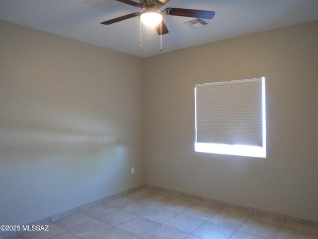 spare room with visible vents, ceiling fan, and baseboards