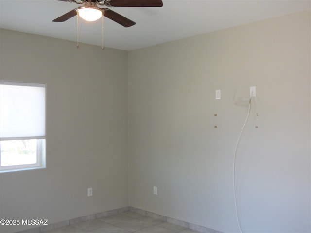 spare room with ceiling fan and baseboards