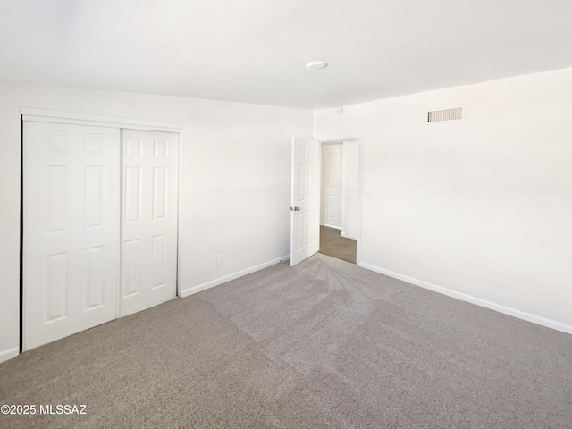 unfurnished bedroom featuring carpet floors and a closet