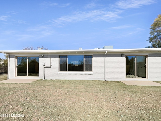 back of property featuring a patio and a lawn